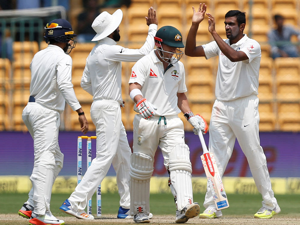 India's Ravichandran Ashwin (R) celebrates the wicket of Australia's David Warner with teammates. REUTERS