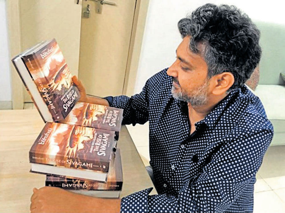 S S Rajamouli, the director of 'Bahubali', holds the book  'The Rise of Sivagami', a prequel to a trilogy on the film.
