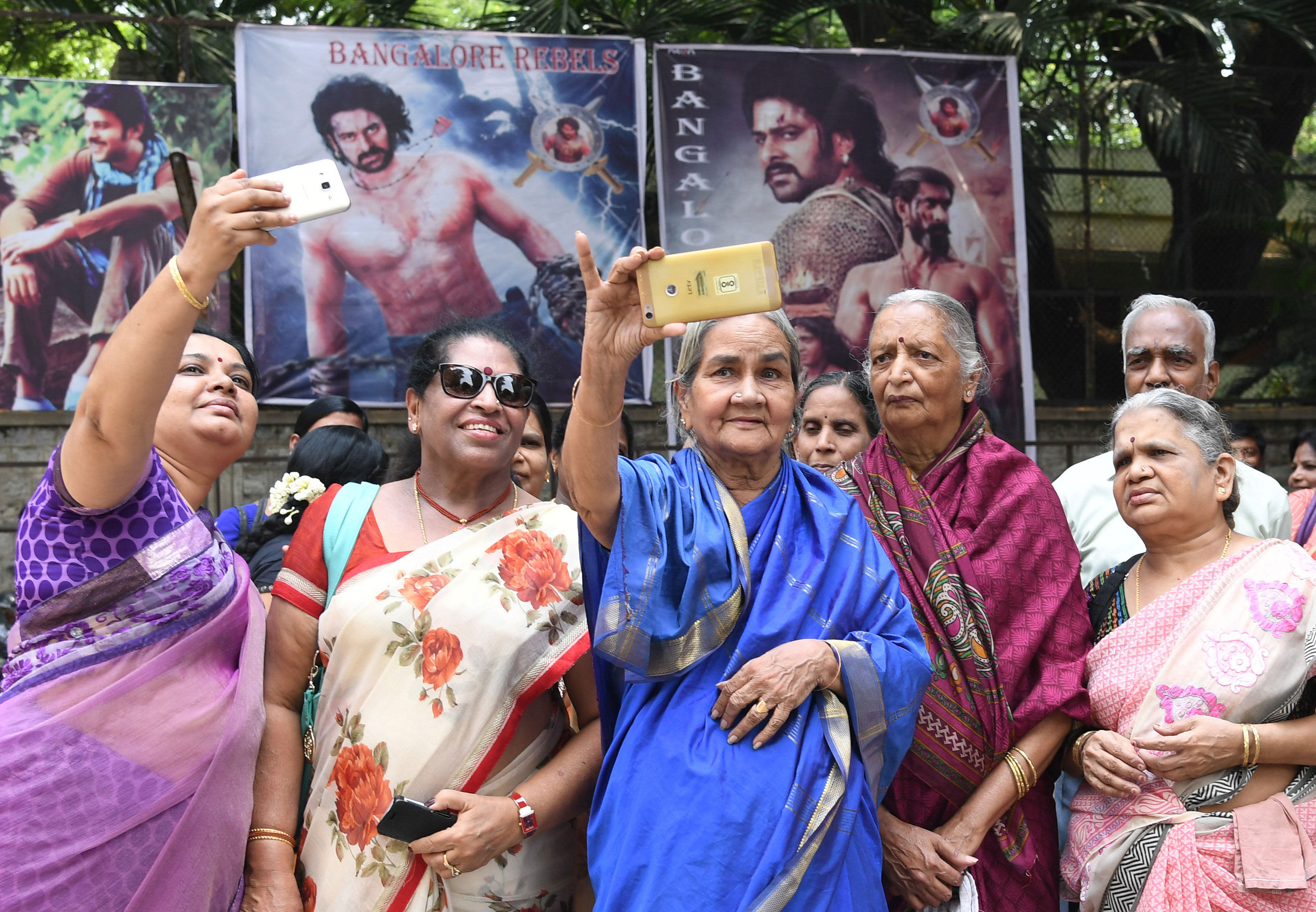 Elder movie enthusiasts snap selfies outside Cauvery theatre in Bengaluru before watching the opening show of Telugu movie Bahubali 2: The Conclusion on Friday. DH Photo by Kishor Kumar Bolar