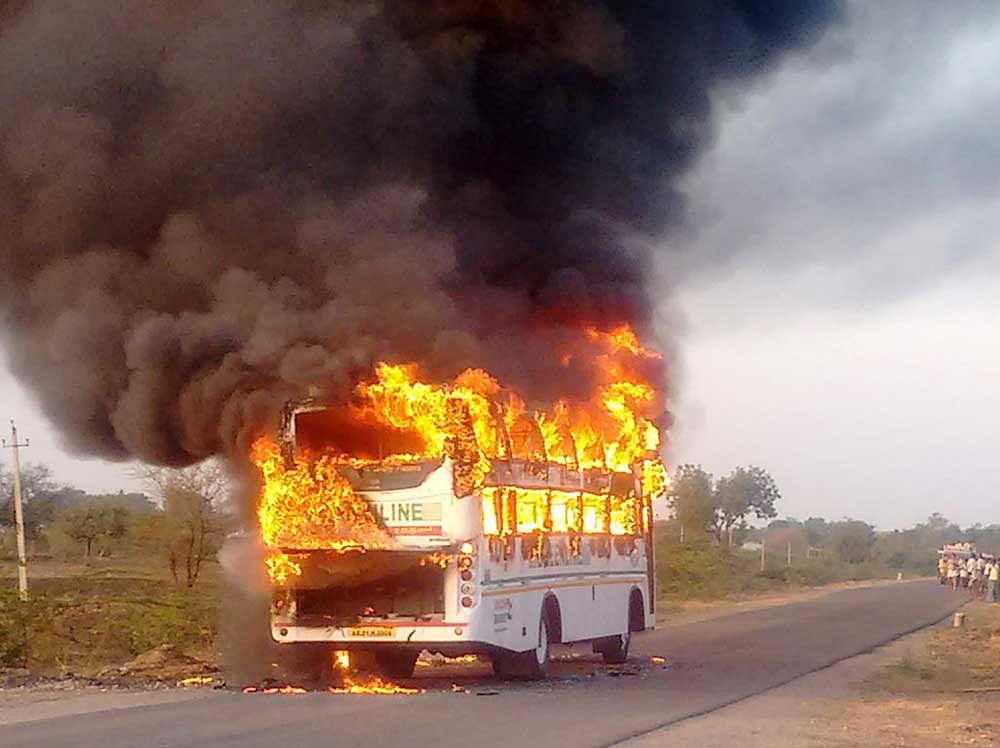 The private bus that caught fire near Halageri in Koppal taluk on Monday. No one was injured in the mishap. DH Photo