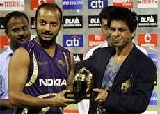 KKR Player Murli Kartik receives the Man of the Match award from his team co-owner Shahrukh Khan after the IPL Match against Mumbai Indians at Eden Garden in Kolkata on Monday night. PTI