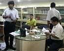 Income Tax officials scan papers during a raid at the office of the Kolkata Knight Riders team of the Indian Premier League in Calcutta, India, Wednesday. AP