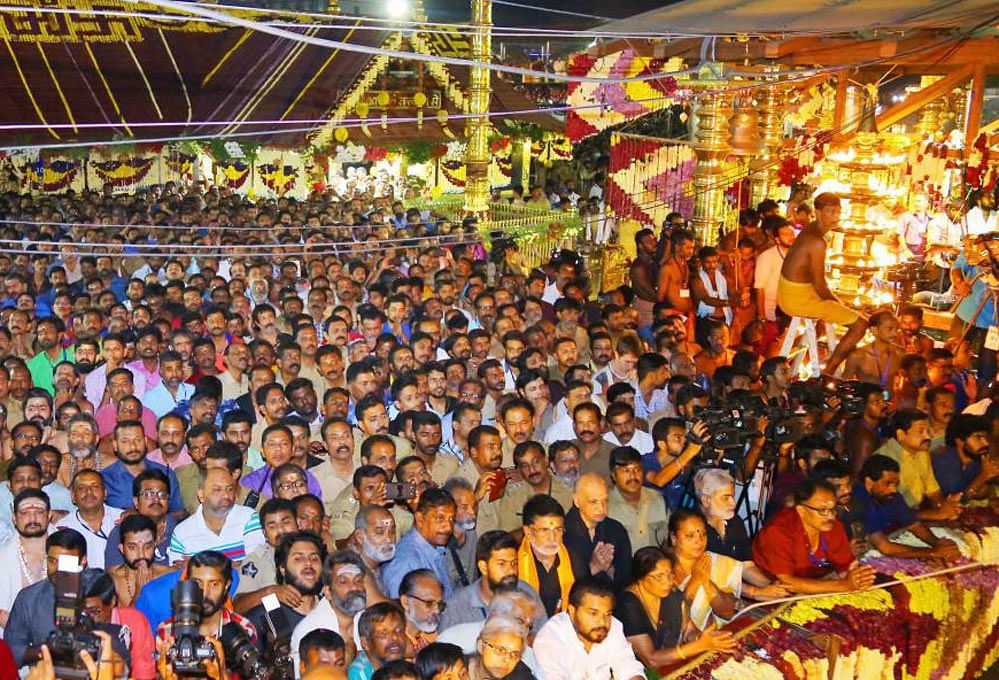 Devotees witness 'Makara Jyothi' on the day of Makaravilakku at Sannidanam in Sabarimala on Sunday. PTI Photo