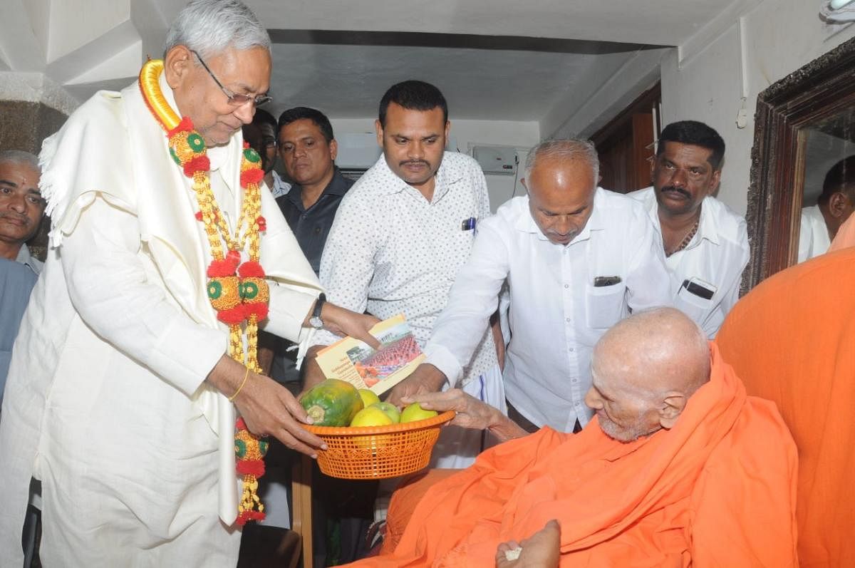 Bihar Chief Minister Nitish Kumar seeks blessings of Siddaganga mutt seer Shivakumara Swamiji in Tumakuru on Sunday.