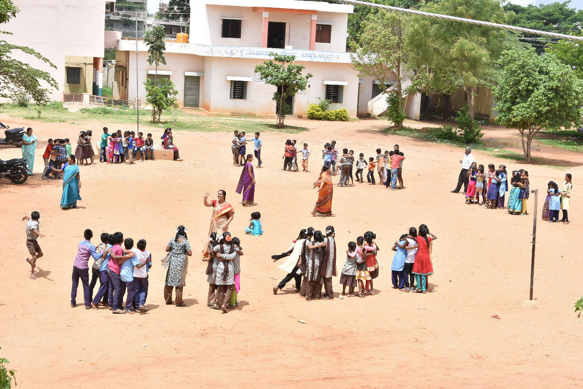 Teachers monitor students who play different games at model higher primary school ground on B B Road in Chikkaballapur town on Saturday DH Photo