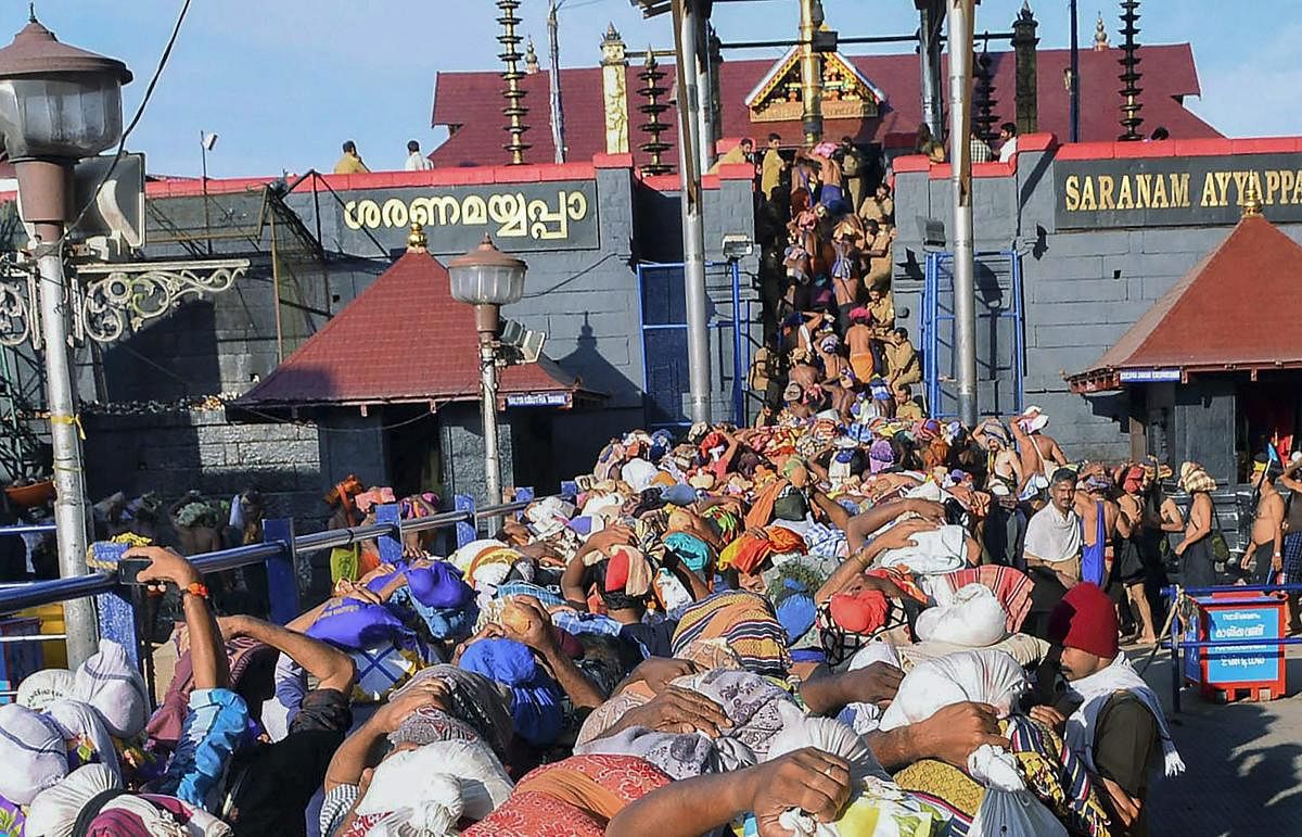 **FILE** Sabarimala: In this file photo dated Nov 18, 2013, devotees wait at Lord Ayyappa temple, in Sabarimala. The Supreme Court today said women have the constitutional right to enter Sabarimala temple in Kerala and pray like men without being discrimi