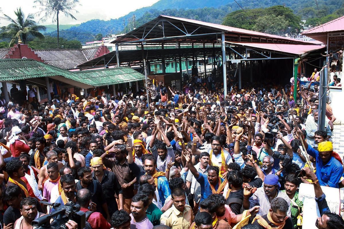 Devotees protest as several female devotees arrive to offer prayers, at Sabarimala temple in the light of the recent verdict by the Supreme Court allowing entry to women of all ages, in the hill shrine, on Sunday. PTI