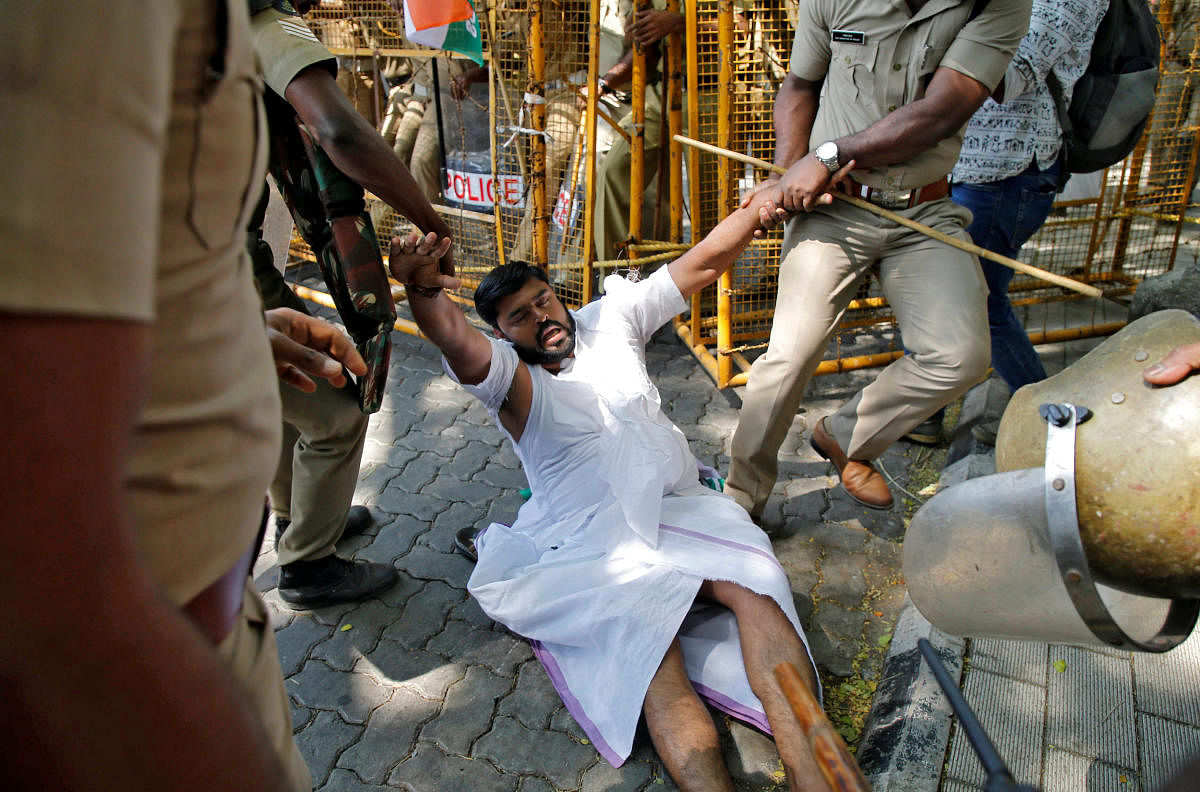 Police officers detain a member of the youth wing of Congress party during a demonstration outside the police commissioner's office demanding to lodge a case against a driver of the cavalcade of the state's chief minister after it hit one of their members