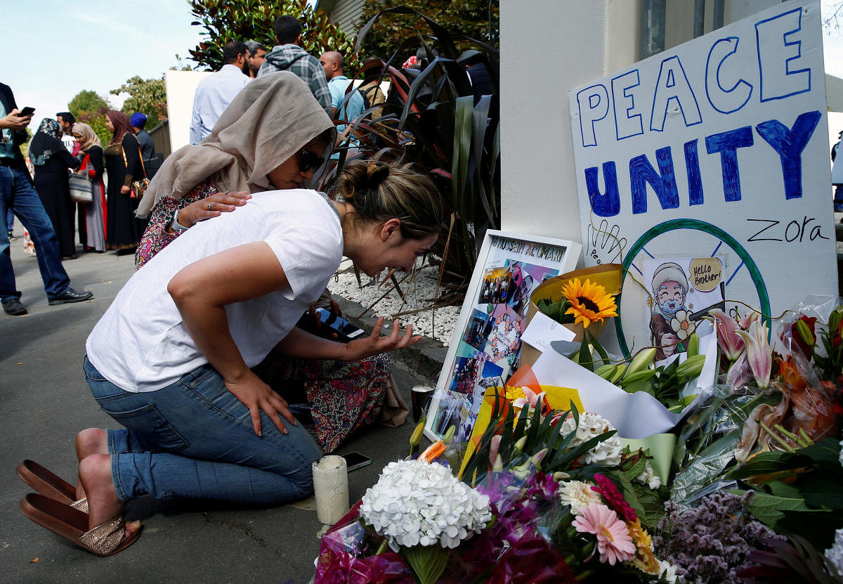 A woman cries next to a tribute to victim Hussein Al-Umari outside Al-Noor mosque after it was reopened in Christchurch, New Zealand. (Reuters Photo)