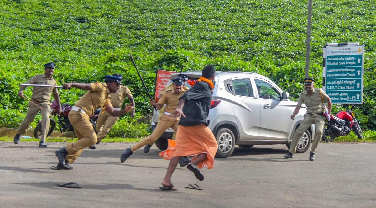 Police lathi-charge one of the protesters after they opposed the entry of girls and women of menstrual age into the hill shrine of Lord Ayyappa Temple in Sabarimala, Kerala, Wednesday, Oct 17, 2018. Tension was witnessed outside the temple on its opening day. PTI