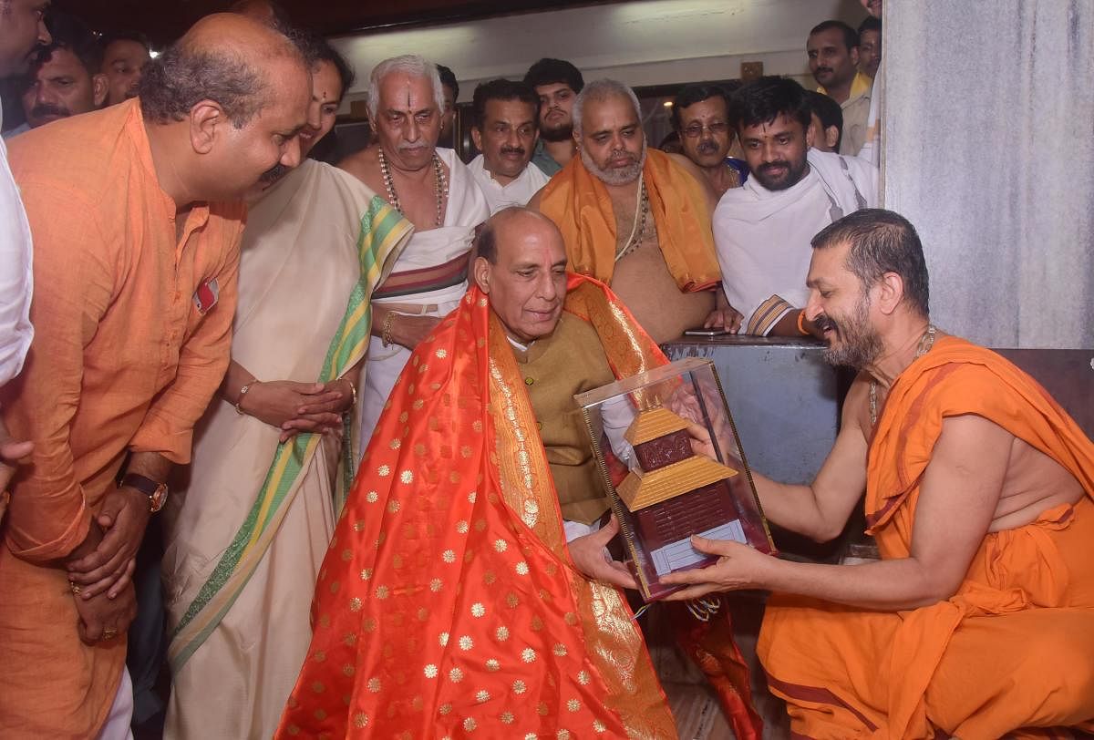 Union Home Minister Rajnath Singh being honoured by Paryaya Palimar Mutt Seer Vidyadheesha Thirtha Swami in Udupi on Monday. DHPV Photo