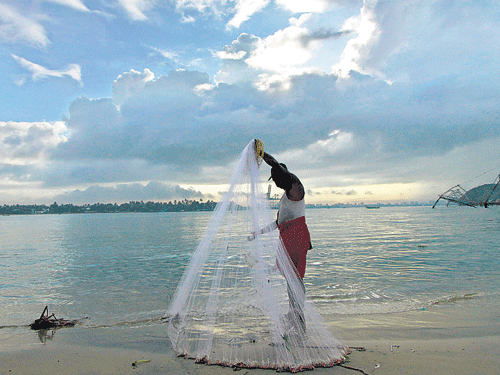 A fisherman arranges his net against the backdrop of pre-monsoon clouds in Kochi on Thursday. Reuters photo