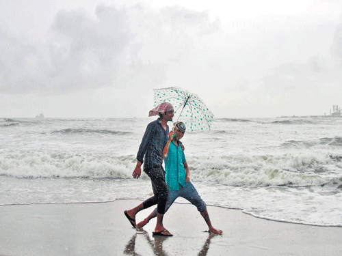 People enjoy drizzle at the Fort Kochi beach on Friday in Kerala. Reuters