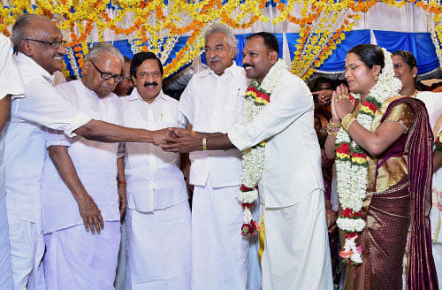 Kerala Chief Minister Oommen Chandy, Home Minister Ramesh Chennithala, Opposition leader V S Achuthanandan and other ministers greet newly-wed minister P.K. Jayalakshmi and groom C.A. Anilkumar at Mananthavady in Wayanad district of Kerala on Sunday. PTI Photo