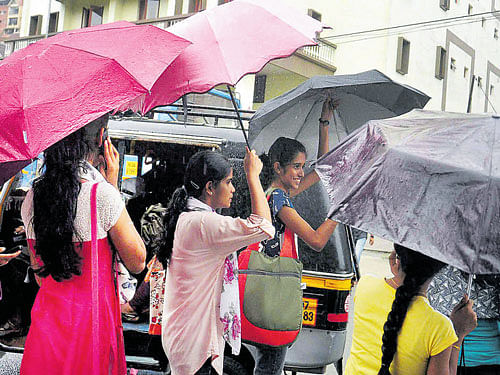Girls enjoy pre-monsoon showers in Kochi on Tuesday. PTI