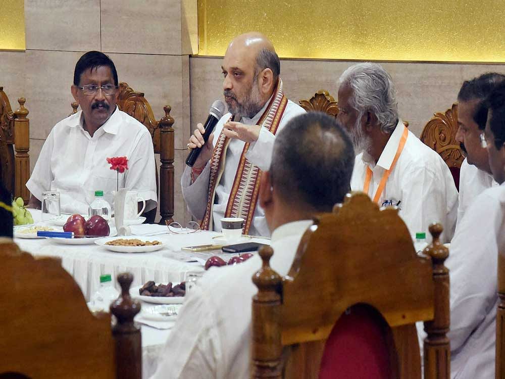 BJP chief Amit Shah with other BJP members during a meeting, as he begins his three-day Kerala visit, in Kochi on Friday.PTI Photo