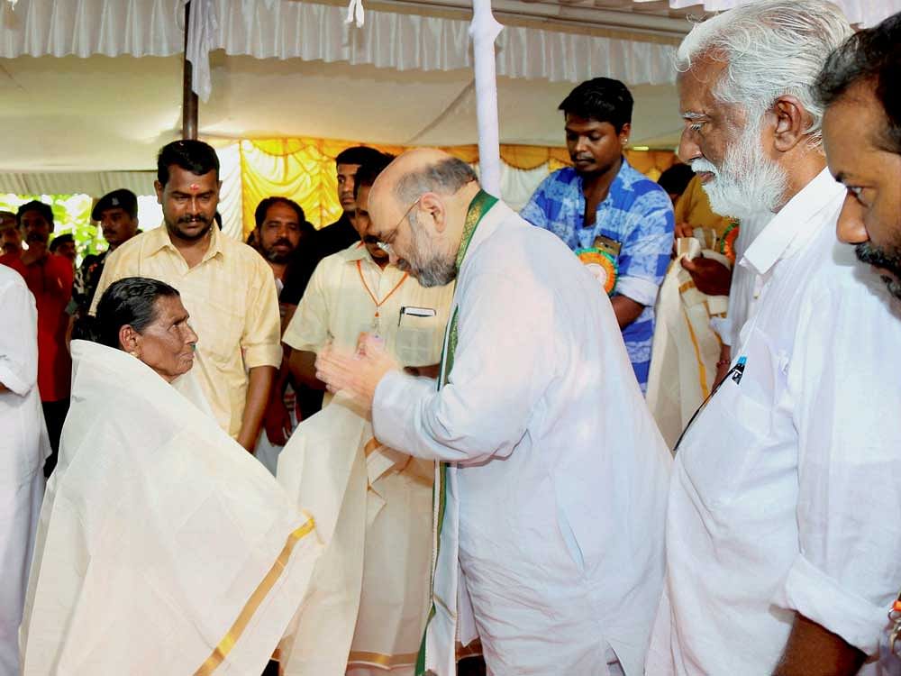 BJP National President Amit Shah honours an elderly worker at the Kerala State BJP booth committee meeting in Trivandrum on Sunday. PTI Photo