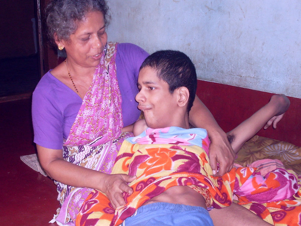 A woman holds a child affected by endosulfan. DH file photo.