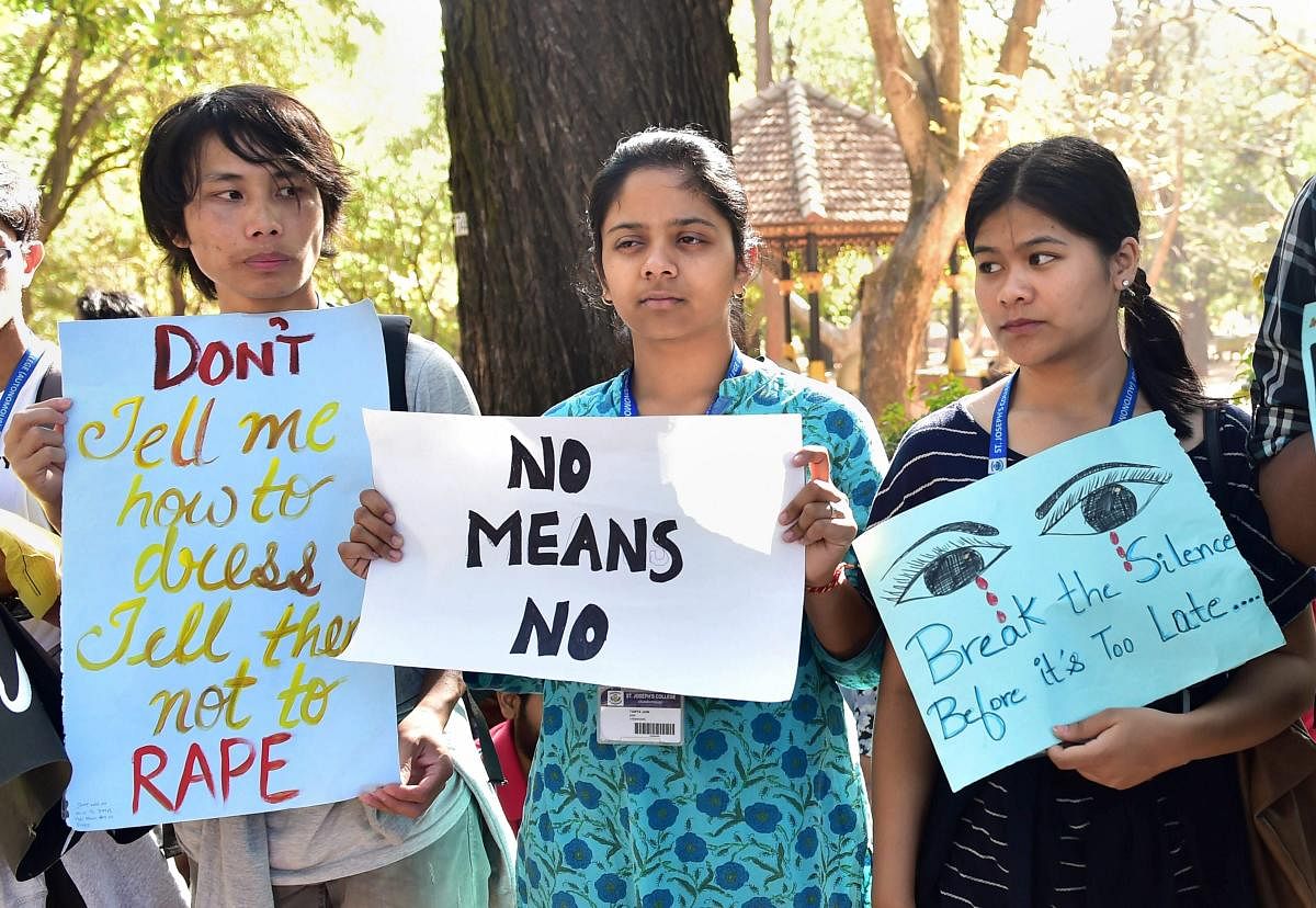 Students display placards as they protest against the violence against women. PTI file photo