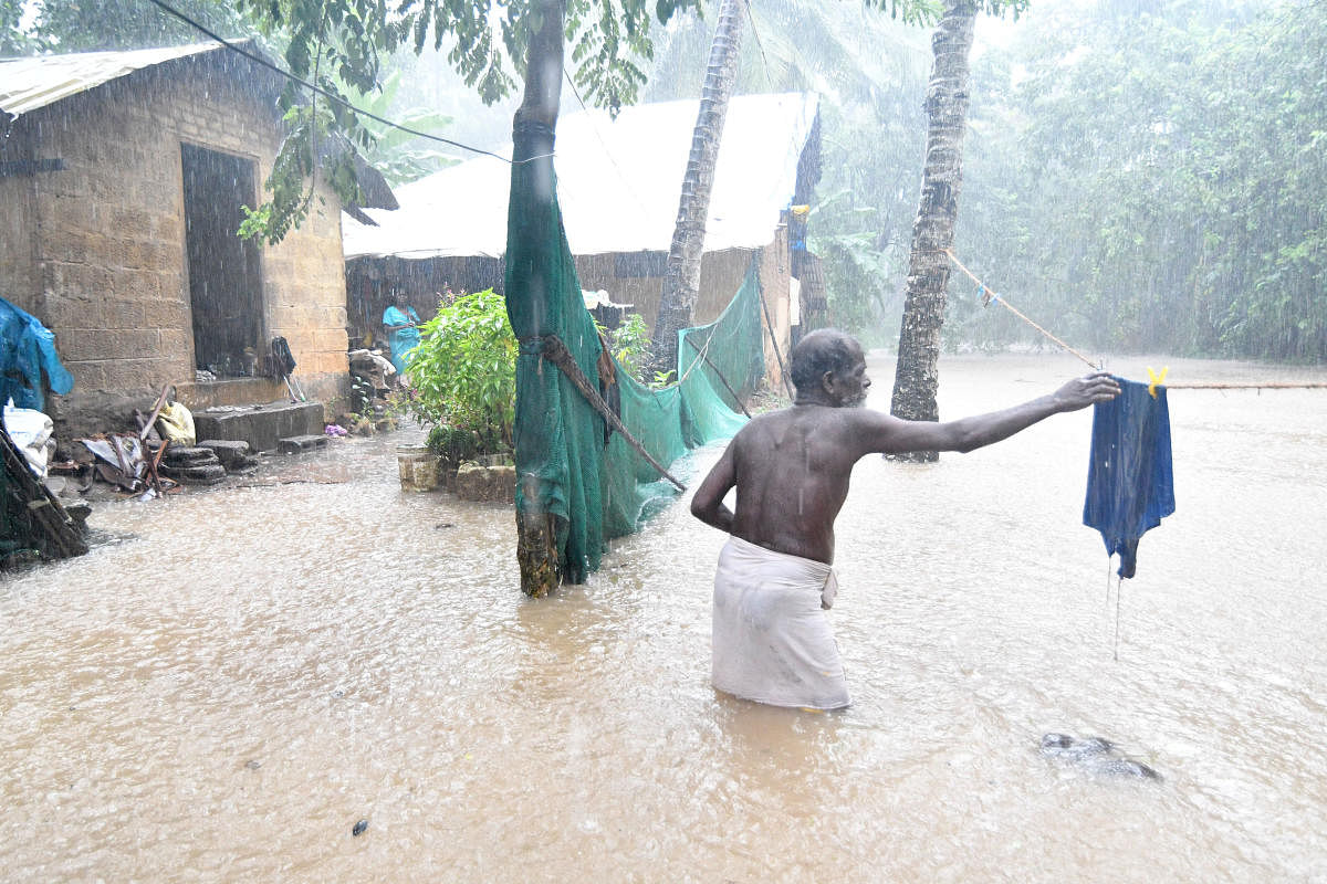 A resident of Puthenpalam in Thiruvananthapuram, where water from an overflowing canal entered residential areas on Tuesday. DH Photo 