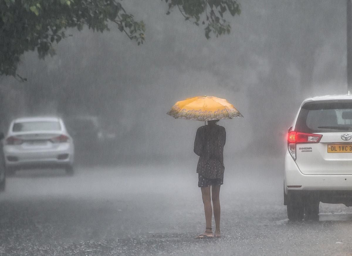 A girl holds an umbrella while walking during monsoon rains in New Delhi on Friday, Aug 10, 2018. PTI Photo