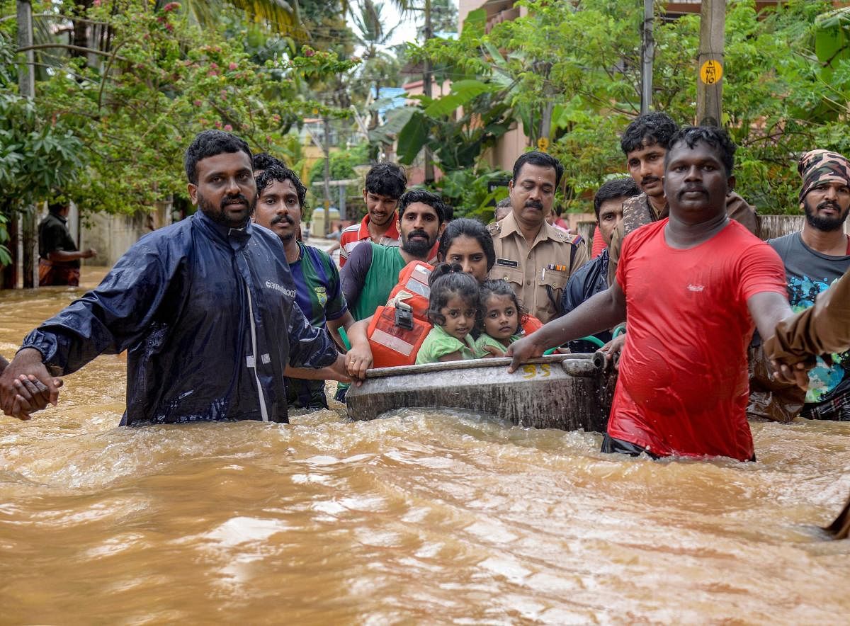 Rescuers evacuate people from a flood-hit locality, in Thiruvananthapuram on Wednesday. (PTI Photo)