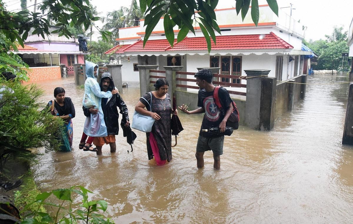 People shift from a flood-hit locality in Kochi on Wednesday. The Cochin International Airport at Nedumbassery reportedly suspended operations till Saturday due to rains and floods. PTI