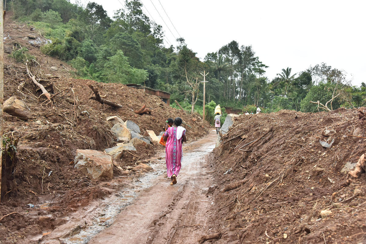 A woman walks through a rubble of houses which were destroyed by landslide at Aanoth Ammara in Wayanad district on Thursday. DH photo by Janardhan BK