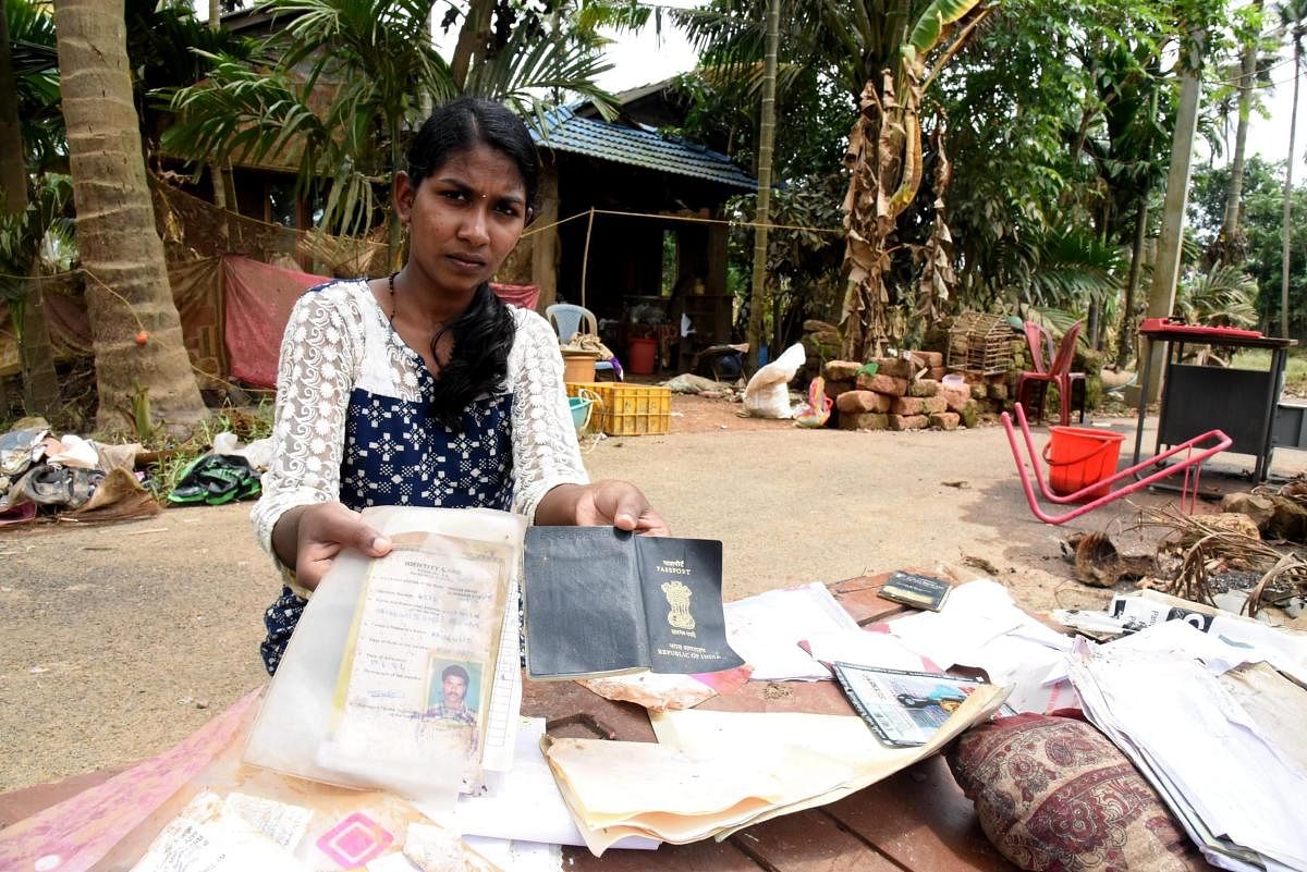 A woman shows her documents damaged due to Kerala floods at Annamanada in Thrissur on Sunday. PTI