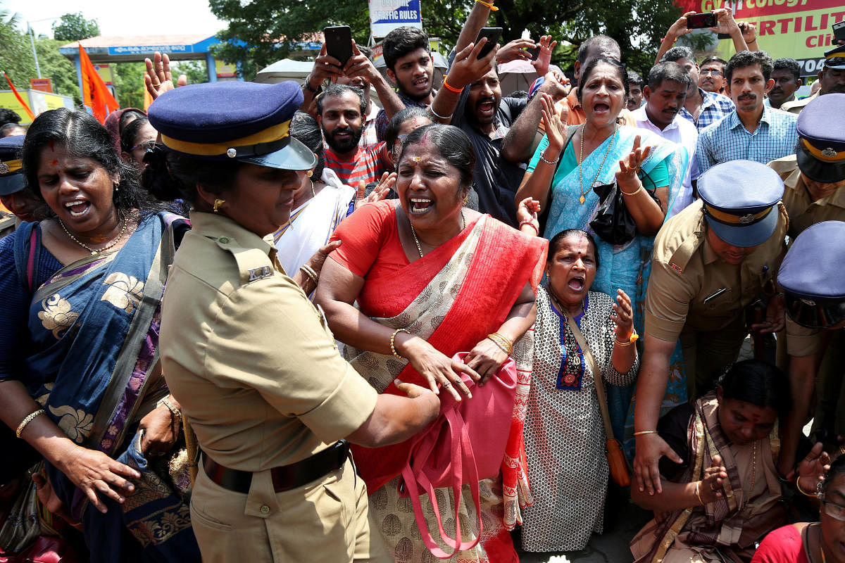 A woman reacts as she is detained by a police officer during a protest called by various Hindu organisations against the lifting of ban by Supreme Court that allowed entry of women of menstruating age to the Sabarimala temple, in Kochi, India, October 10,