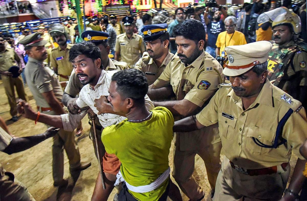Police personnel detain the devotees who were staging 'Namajapa' protest against the police restrictions at Sannidhanam, in Sabarimala, Sunday night, Nov. 18, 2018. (PTI Photo)