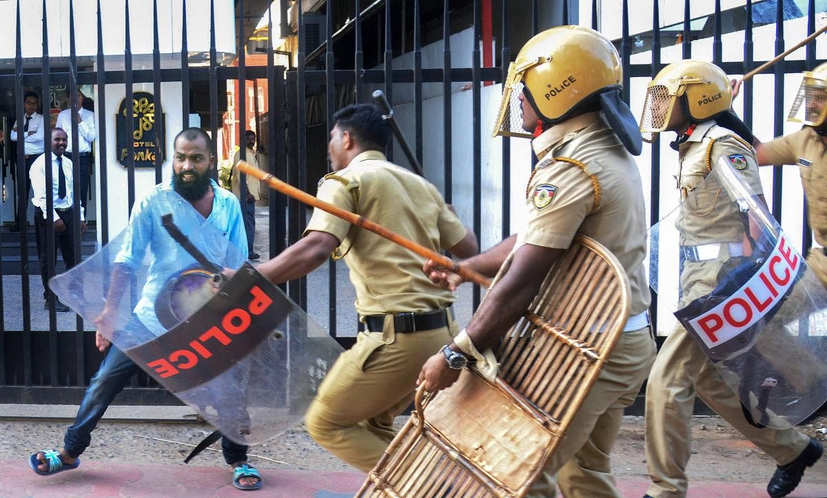 Policemen chase away a demonstrator during a protest against the entry of two women to the Sabarimala temple, in Thiruvananthapuram on January 2, 2019. PTI