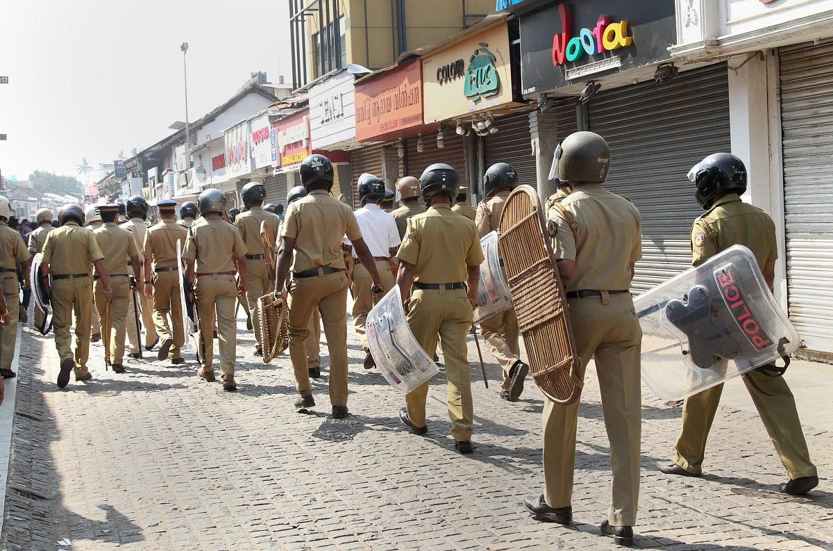 Police personnel patrol at a closed market during Congress party's statewide 'black day' strike on the issue of the entry of two women of menstruating age into the Sabarimala temple of Lord Ayyappa, in Kozhikode. PTI file Photo