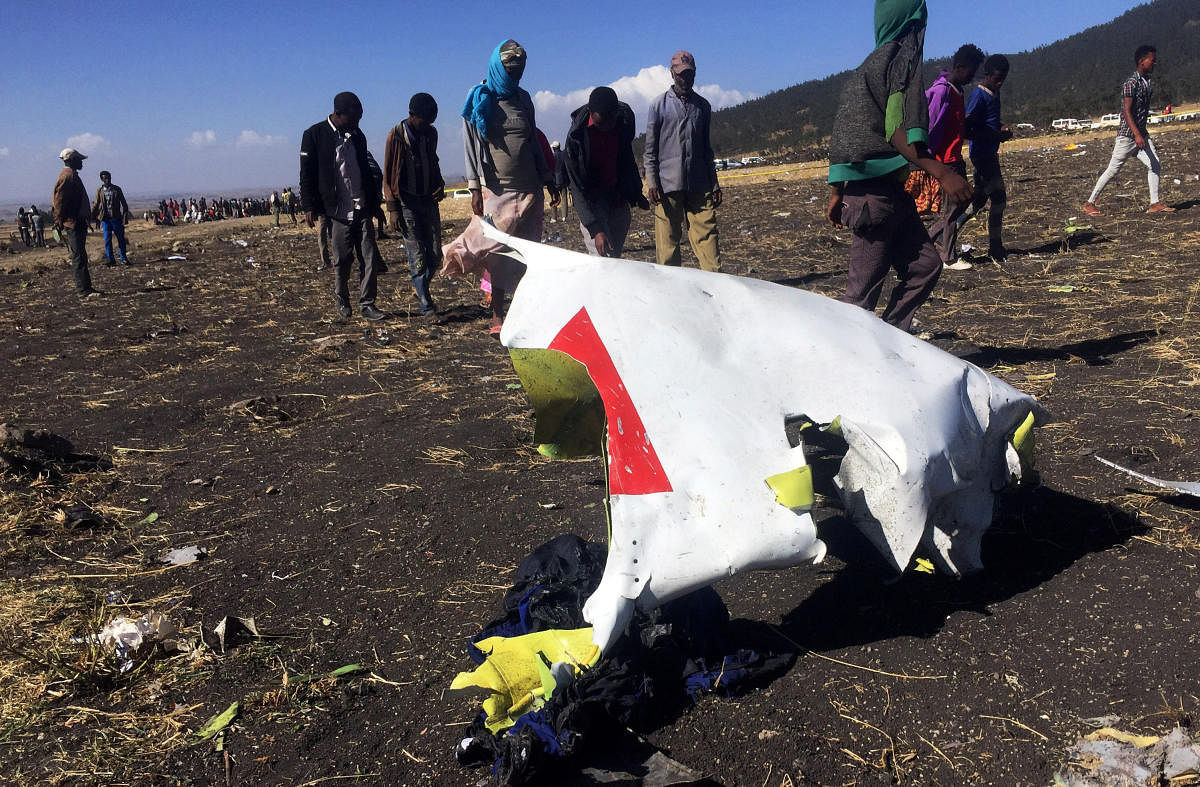 FILE PHOTO: People walk past a part of the wreckage at the scene of the Ethiopian Airlines Flight ET 302 plane crash, near the town of Bishoftu, southeast of Addis Ababa, Ethiopia March 10, 2019. REUTERS/Tiksa Negeri/File Photo