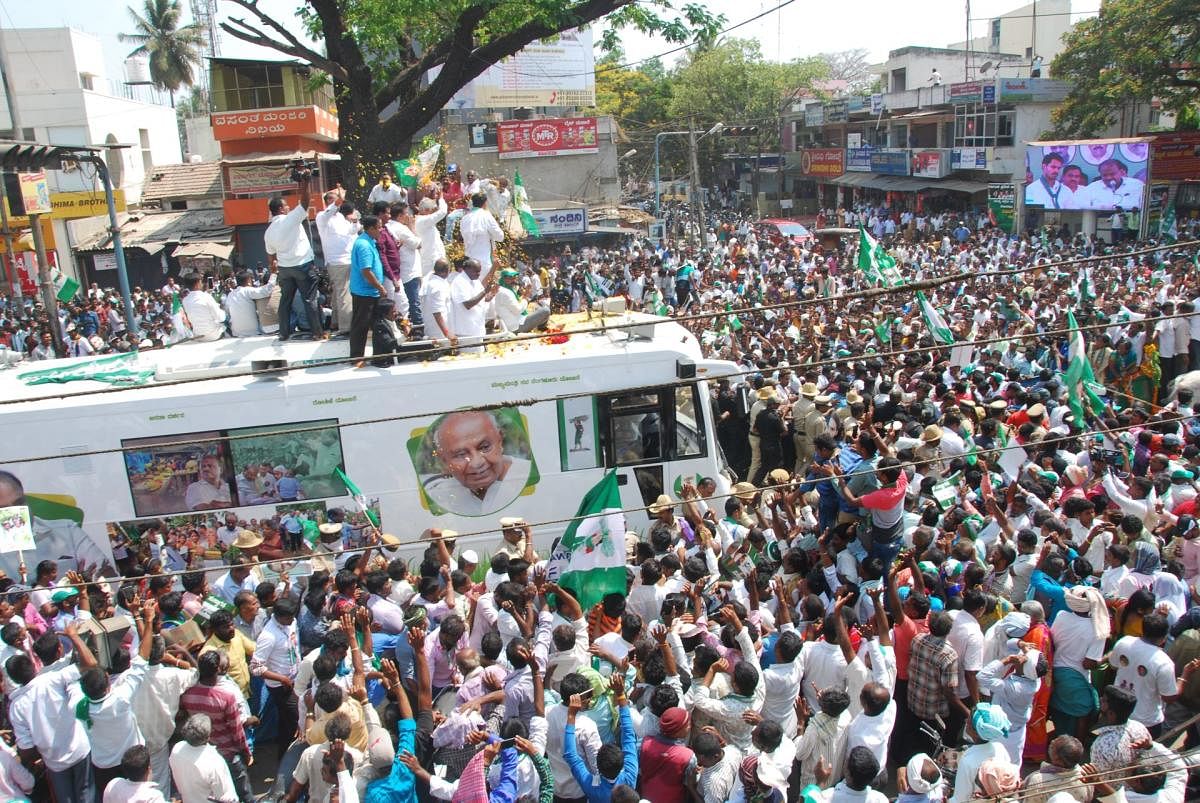 Hundreds of JD(S) workers take part in a procession with their candidate Nikhil Kumaraswamy in Mandya on Monday while he was on his way to file nomination papers. (Right) Chief Minister H D Kumaraswamy addresses JD(S) and Congress workers. DH photo