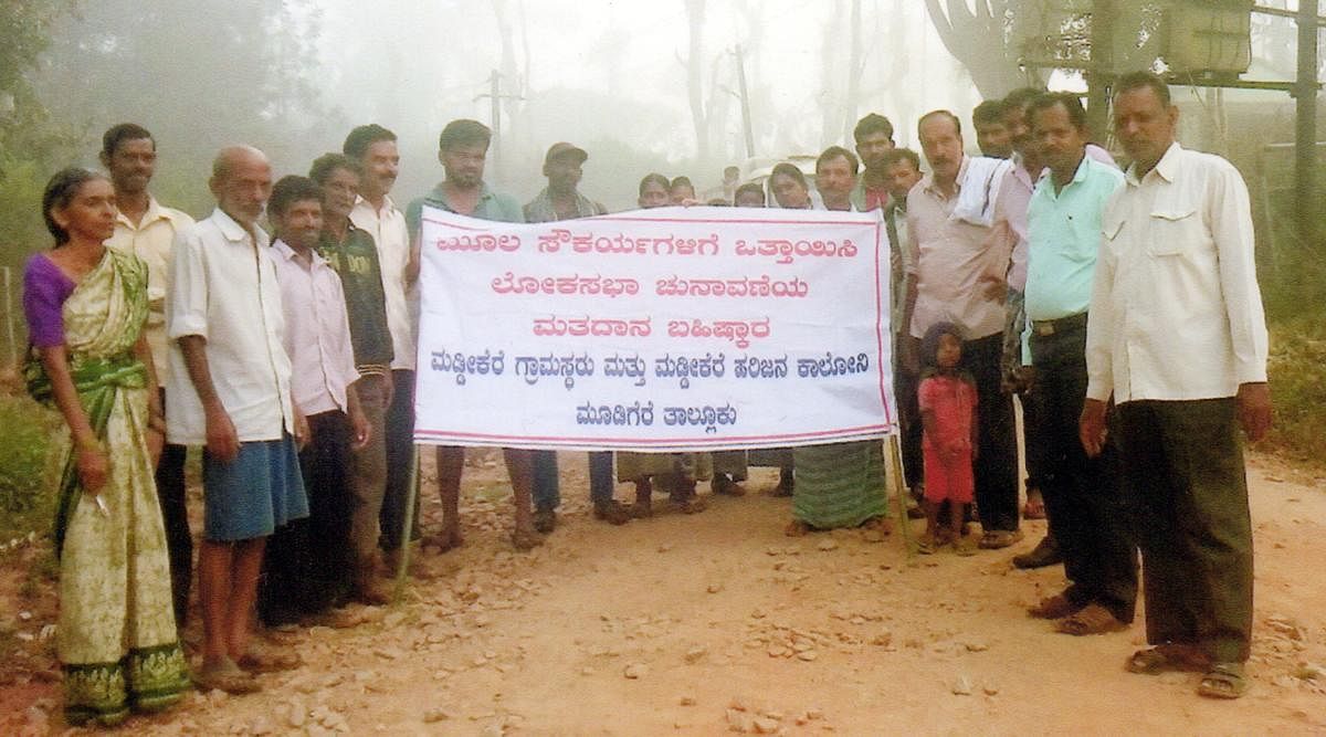 Villagers of Maddikere hold a banner declaring their intent to boycott the Lok Sabha elections.