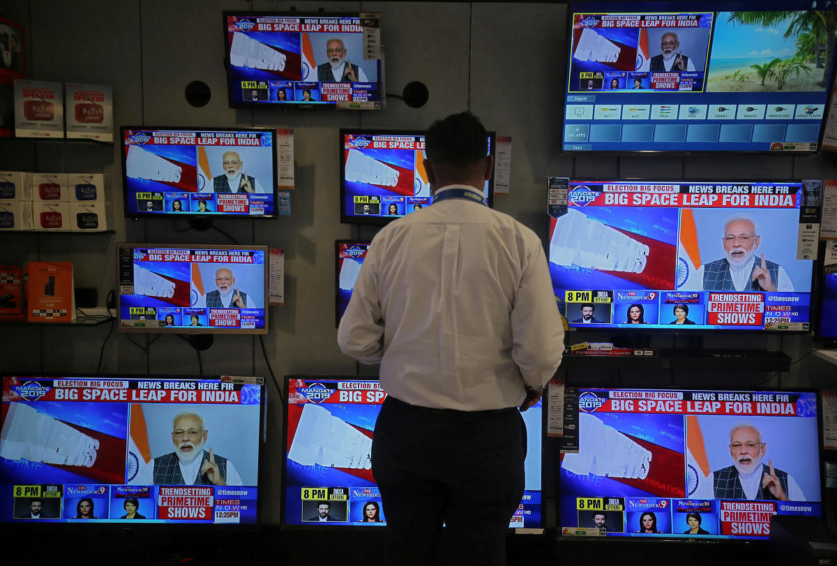 A salesman watches Prime Minister Narendra Modi addressing to the nation, on TV screens inside a showroom in Mumbai, India, March 27, 2019. (REUTERS)