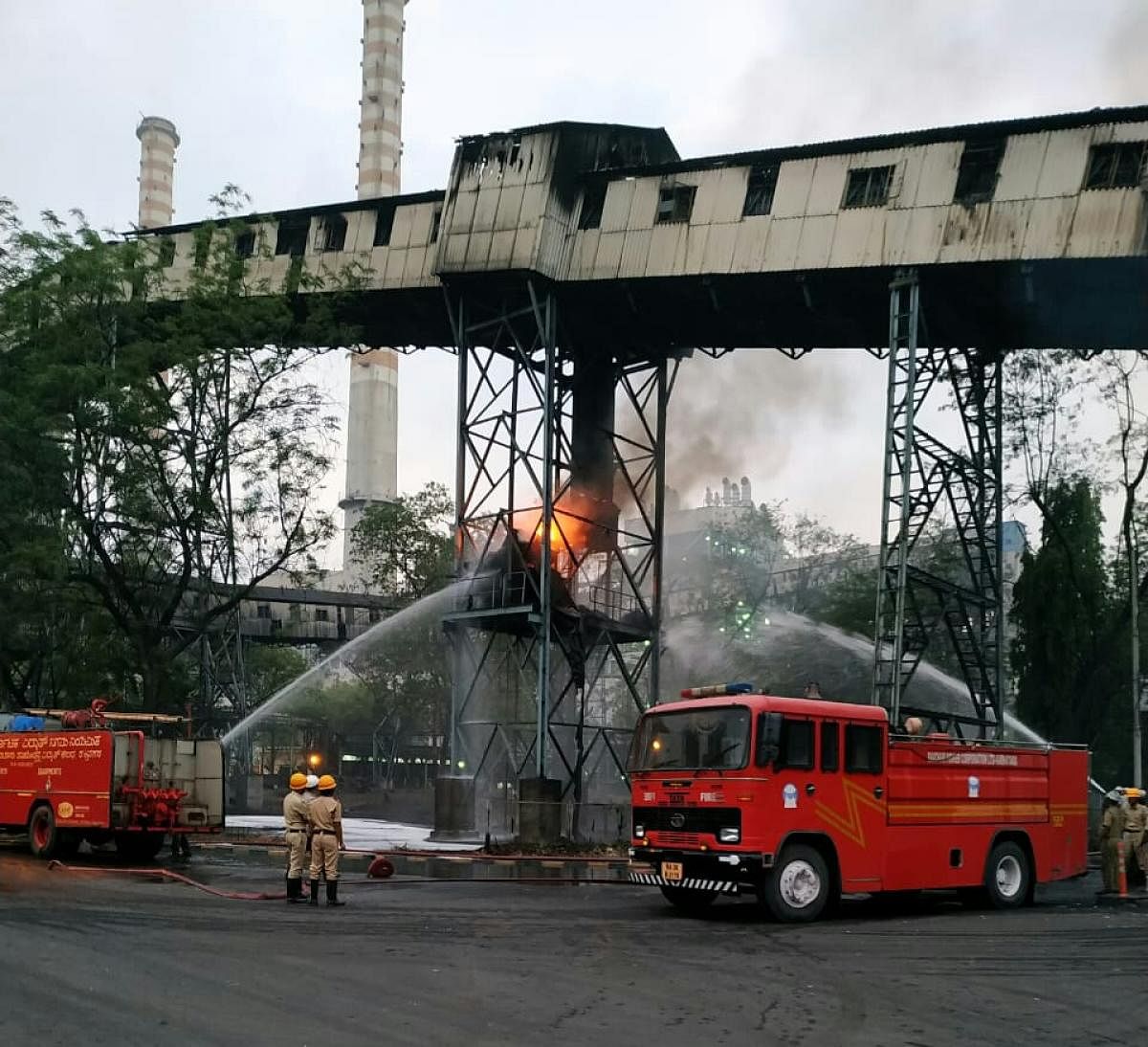 Fire and Emergency Services Department personnel extinguish the fire which broke out in a conveyor belt in the coal section of RTPS at Shakthinagar, Raichur. DH photo
