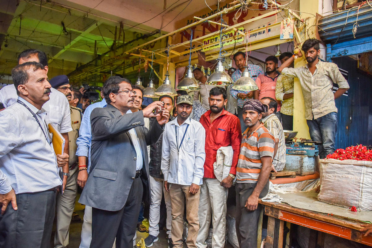 Manjunath Prasad N, Commissioner BBMP inspecting K R Market with officials, as per the High Court direction, looking illegal shop constructions and fire safety, free movement of fire fighting vehicles in the market, in Bengaluru on Thursday. Photo by S K
