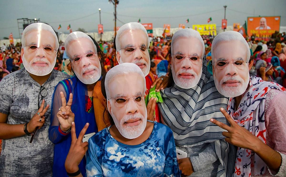 Jammu: BJP supporters wear masks of Prime Minister Narendra Modi to extend their support during a public rally ahead of Lok Sabha elections, at Dumi village near Jammu, Thursday, March 28, 2019. (PTI Photo) (PTI3_28_2019_000139A)