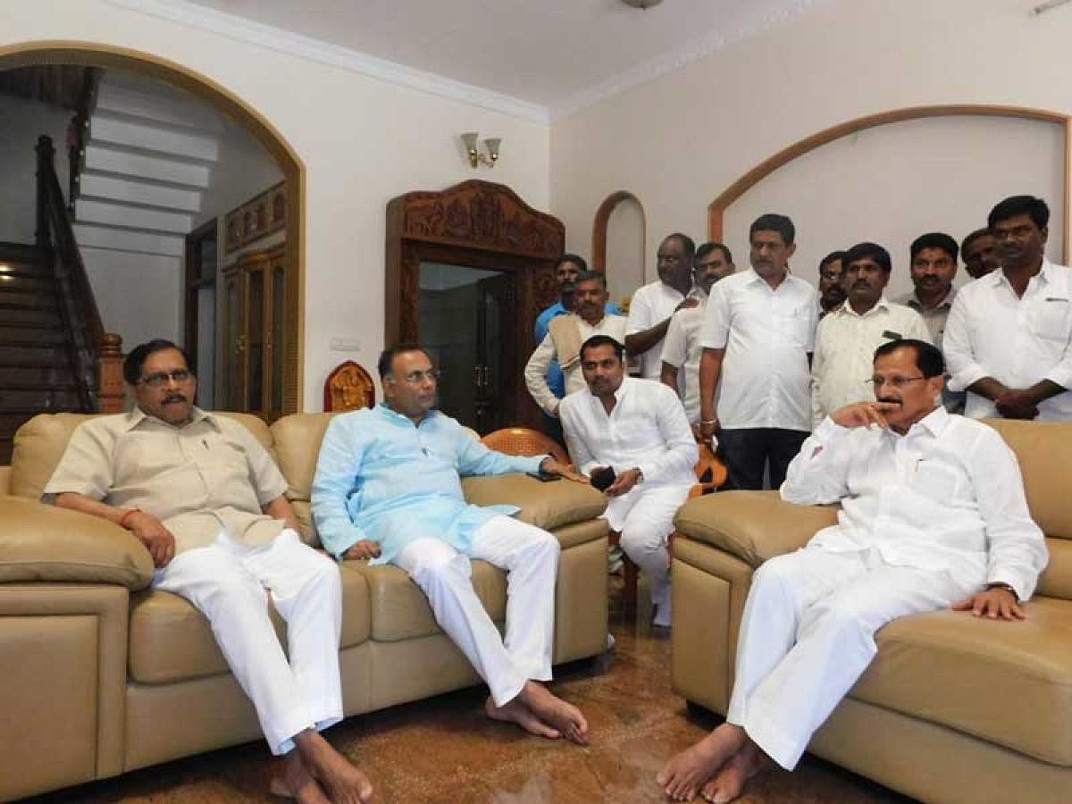 Deputy Chief Minister G Parameshwara, KPCC president Dinesh Gundu Rao holds talks with Tumkur MP S P Muddahanumegowda at latter's residence in Bengaluru on Friday. DH PHOTO