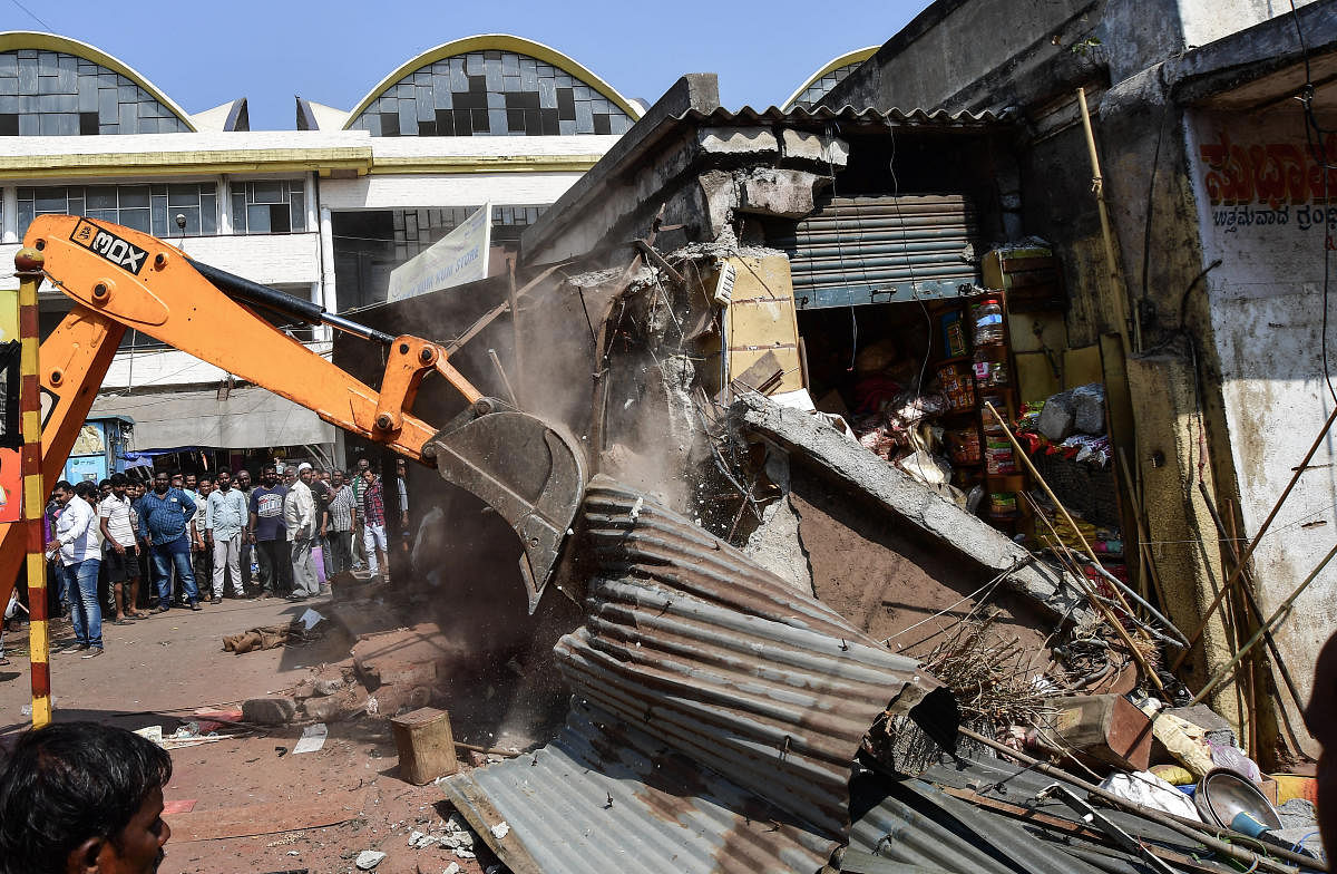 A crane pulls down an unauthorised shop in KR Market on Friday. DH PHOTO/ANAND BAKSHI