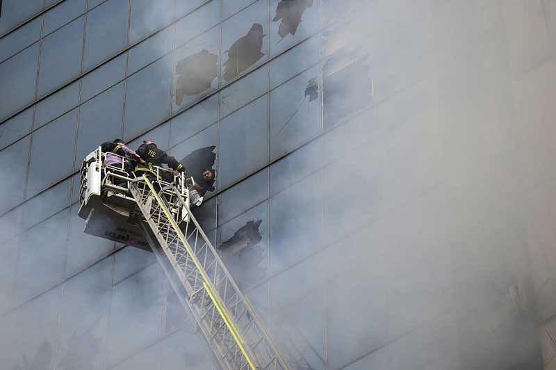 The blaze that burned for several hours on Thursday trapped people inside the building, some shouting for help from windows on upper floors and the roof. (AFP Photo)