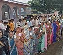 People stand in queues to cast their votes at a polling booth during the third phase of Bihar assembly elections, in Raghopur on Thursday. PTI