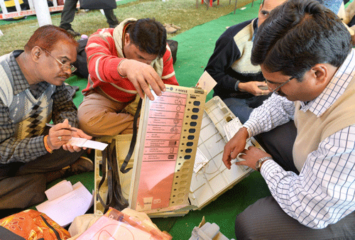 Poll officials check Elctronic Voting Machines (EVM) and other election materials distributed to them before Madhya Pradesh state assembly elections in Bhopal on Sunday. PTI Photo