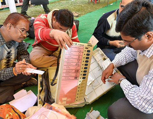 Poll officials check Elctronic Voting Machines and other materials distributed to them before Madhya Pradesh Assembly elections in Bhopal on Sunday. PTI