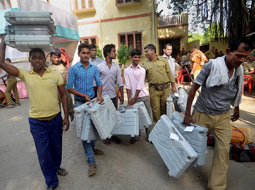 Polling officers carry EVMs as they leave for polling stations ahead of elctions in Patna on Wednesday. PTI Photo