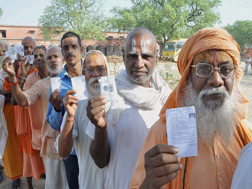 Sadhus standing in a queue to cast their votes for Lok Sabha polls at a polling booth in Vrindavan on Thursday. PTI Photo