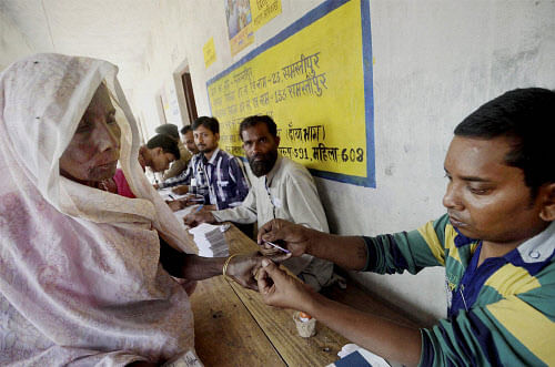 A polling officer puts ink mark on a voter's finger at a polling station in Samastipur on Wednesday. PTI photo
