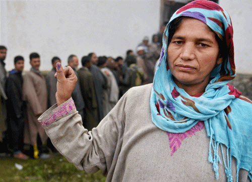 A woman voter displays the indelible ink mark after casting her vote for Assembly elections at a polling station in Bandipora district of Jammu and Kashmir on Tuesday. 15 assembly segments went to polling in the first phase of elections in the state. PTI Photo
